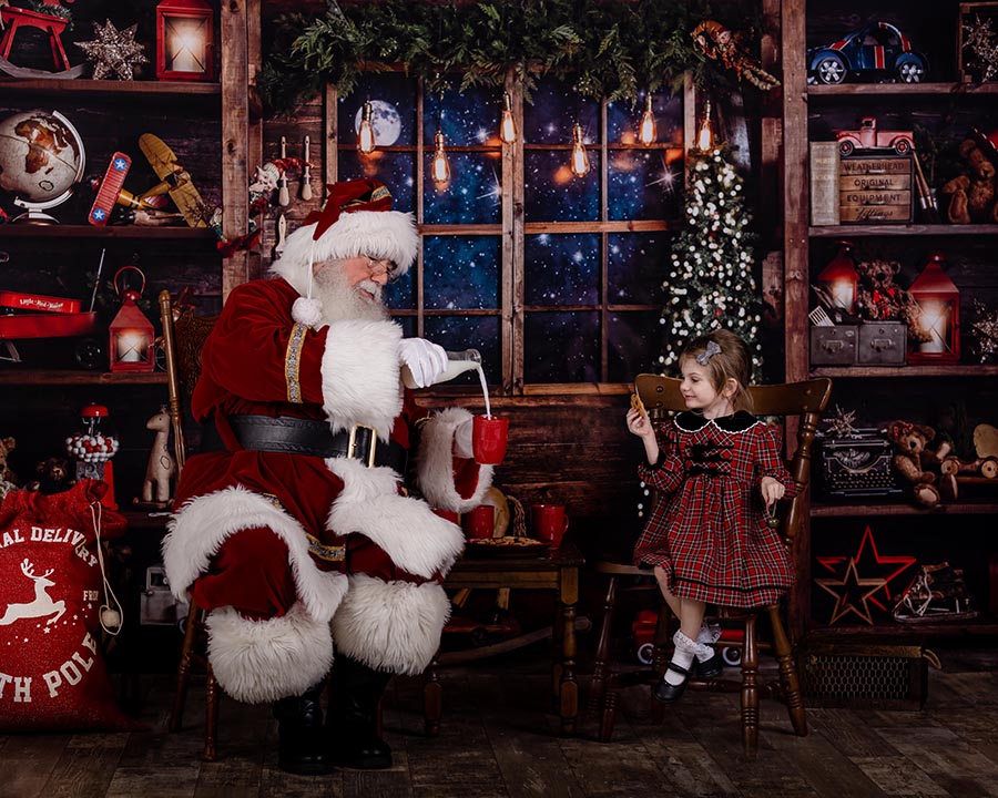 little girl having milk and cookies with Santa during the Santa photo session